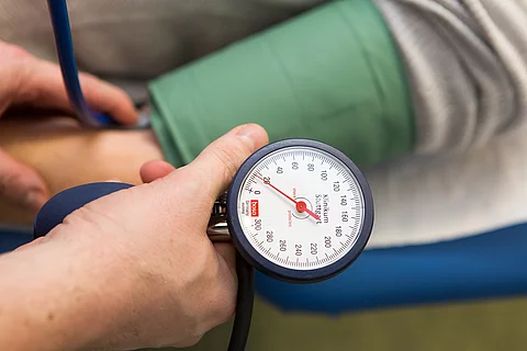 Arzt misst den Blutdruck eines Patienten. 