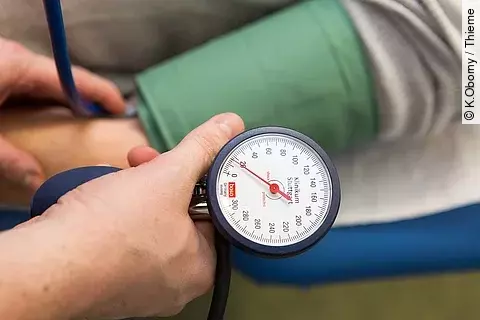 Arzt misst den Blutdruck eines Patienten. 