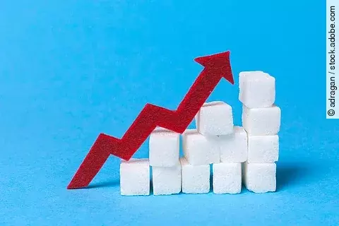 Treppe aus Würfelzucker mit rotem Pfeil nach oben