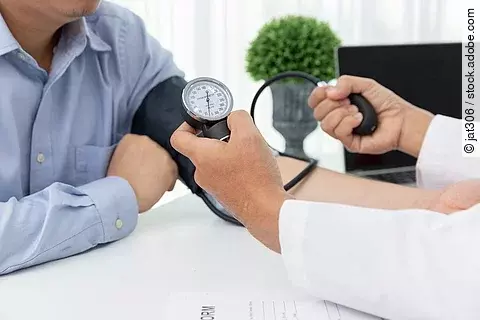 Arzt misst Blutdruck bei einem Patienten