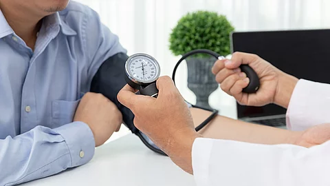 Arzt misst Blutdruck bei einem Patienten