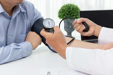 Arzt misst Blutdruck bei einem Patienten