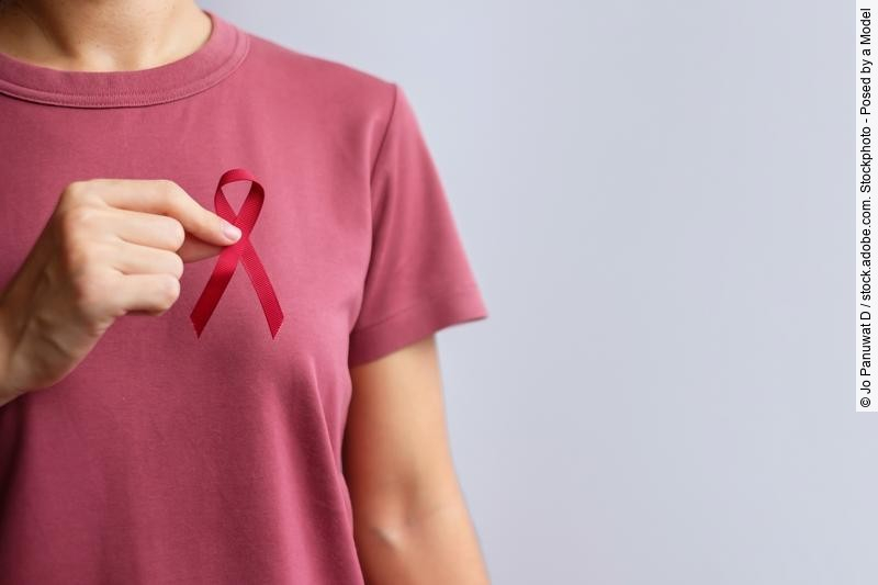 Frau im roten T-Shirt hält Brustkrebsschleife