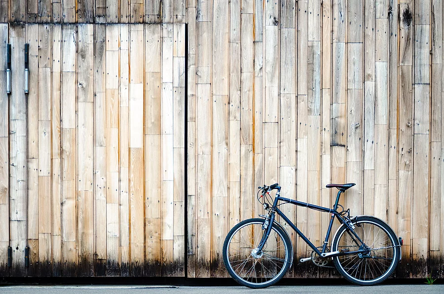 Parkplatz Fahrrad lehnt an einem großen Holztor