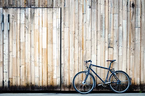 Fahrrad lehnt an einem großen Holztor