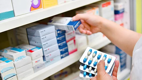 Apothekerin räumt Arzneimittel ins Regal. 