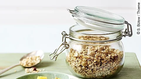 Weckglas mit Haferflocken, Schale mit Obst und Haferflocken