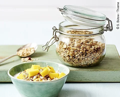 Weckglas mit Haferflocken, Schale mit Obst und Haferflocken