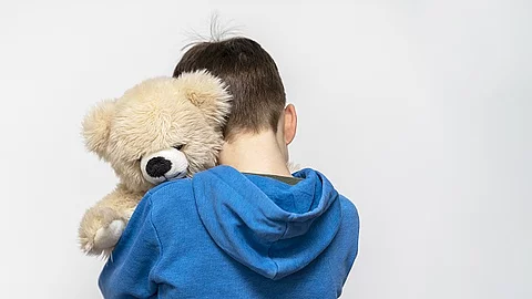 Ein Junge umarmt seinen Teddybär. 