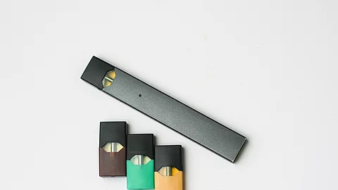 E-cigarette on white E-Zigarette und Liquid-Fläschchen