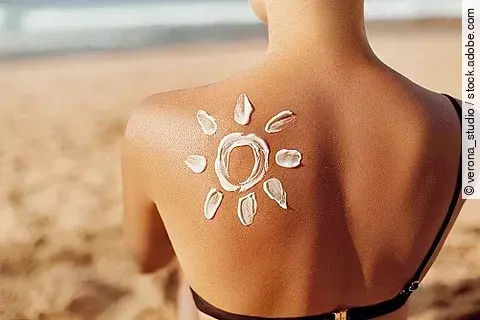 Rücken mit einer Sonne aus Sonnencreme.