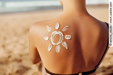 Rücken mit einer Sonne aus Sonnencreme.