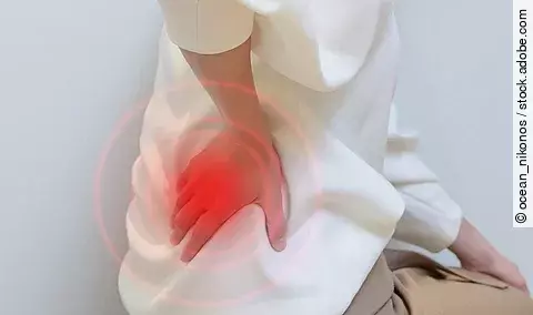 Frau hält sich die Schmerzende Hüfte.