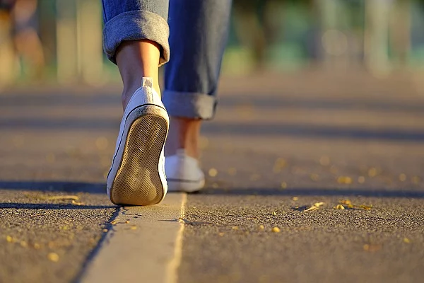 Frauenbeine in Turnschuhen und Jeans, Spaziergang