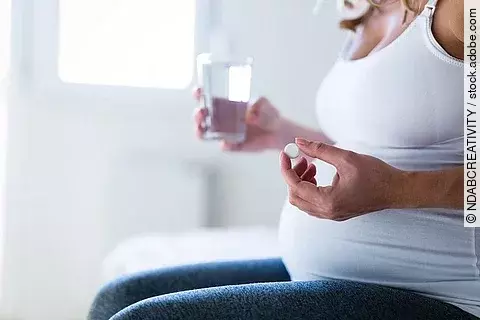 Schwangere Frau nimmt Nahrungsergänzung ein.