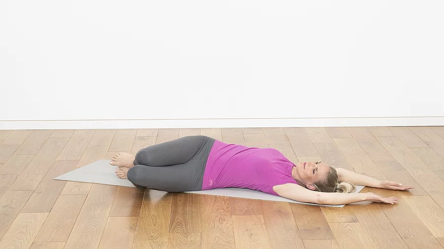 Frau liegt auf dem Rücken, Beine aufgestellt unf nach links gedreht