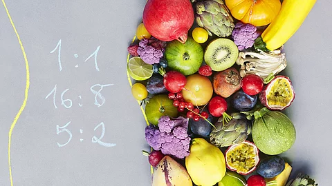 rechts Obst und Gemüse, links mit Kreide geschrieben Intervallfastenformen: 16:8, 5:2 rechts Obst und Gemüse, links mit Kreide geschrieben Intervallfastenformen: 16:8, 5:2