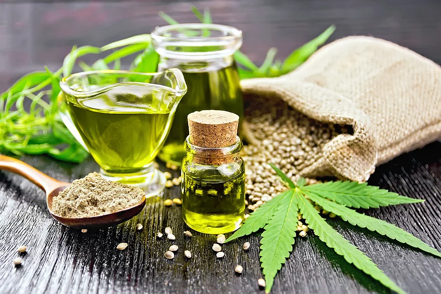 Cannabis-Öl, Cannabisblätter, ein Leinensäckchen mit Cannabissamen auf Holzuntergrund Cannabis-Öl, Cannabisblätter, ein Leinensäckchen mit Cannabissamen auf Holzuntergrund