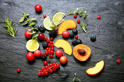 Früchte, Beeren, Kräuter auf einem Granitteller