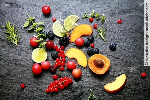 Früchte, Beeren, Kräuter auf einem Granitteller