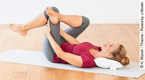 Frau in Rückenlage dehnt Piriformis