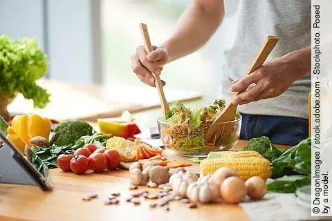 Mann mixt Rohkostsalat