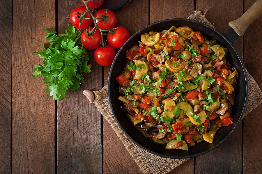 Vegetable Ratatouille in frying pan on a wooden table Ratatouille in einer Pfanne auf einem Holztisch