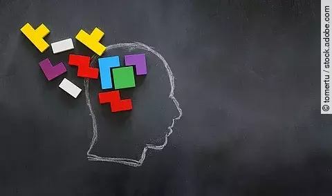 mit Kreide gemalter Kopf aus dem Puzzle-Teile entweichen; Symbolbild für Demenz