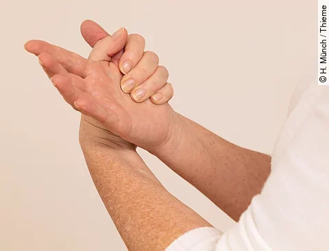 Frau umfasst mit der linken Hand den rechten Daumen