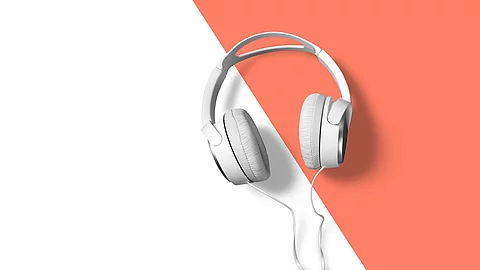 Weiße Kopfhörer auf weiß-orangem Hintergrund