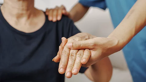 Therapeut*in bewegt den Arm einer Patientin