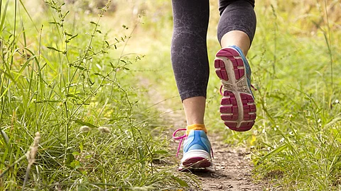 Joggende Frau auf einem Wiesenweg
