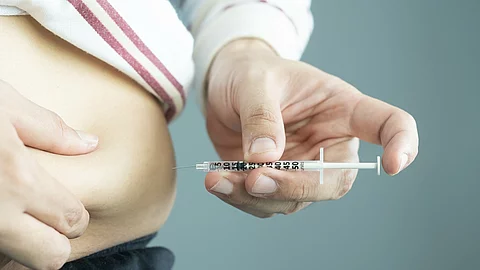 Mann mit Adipositas spritzt sich in den Bauch