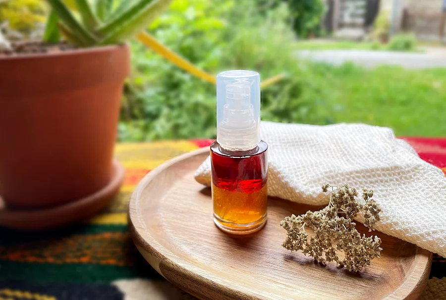 Braunfläschchen mit Hautlotion arrangiert mit einer Aloepflanze auf einem Holztisch