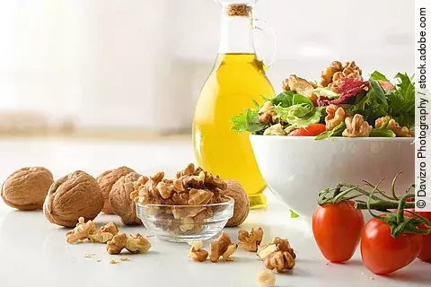 Mediterrane Ernährung: Olivenöl, Walnüsse, Tomaten, eine Salatschüssel
