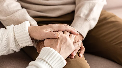 cropped view of senior man and woman holding hands