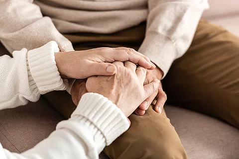 cropped view of senior man and woman holding hands
