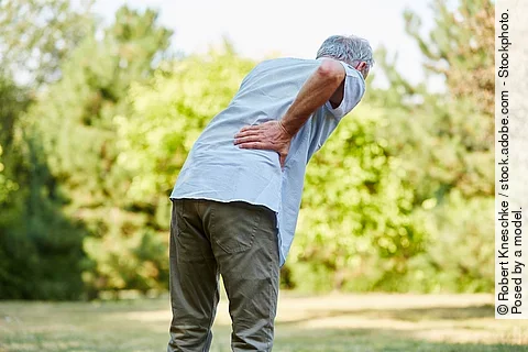 Alter Mann mit Rückenschmerzen in der Natur