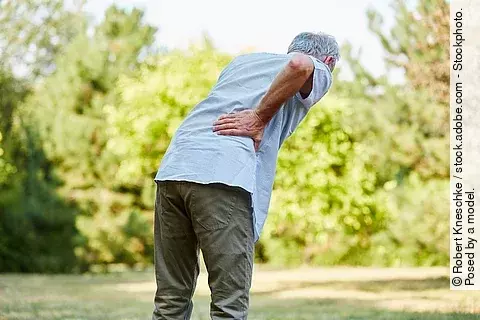 Alter Mann mit Rückenschmerzen in der Natur