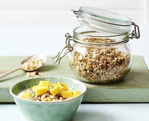 Schale mit Müsli und ein Weckglas mit Haferflocken