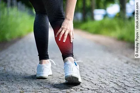 Frau beim Joggen, hat Wadenschmerz