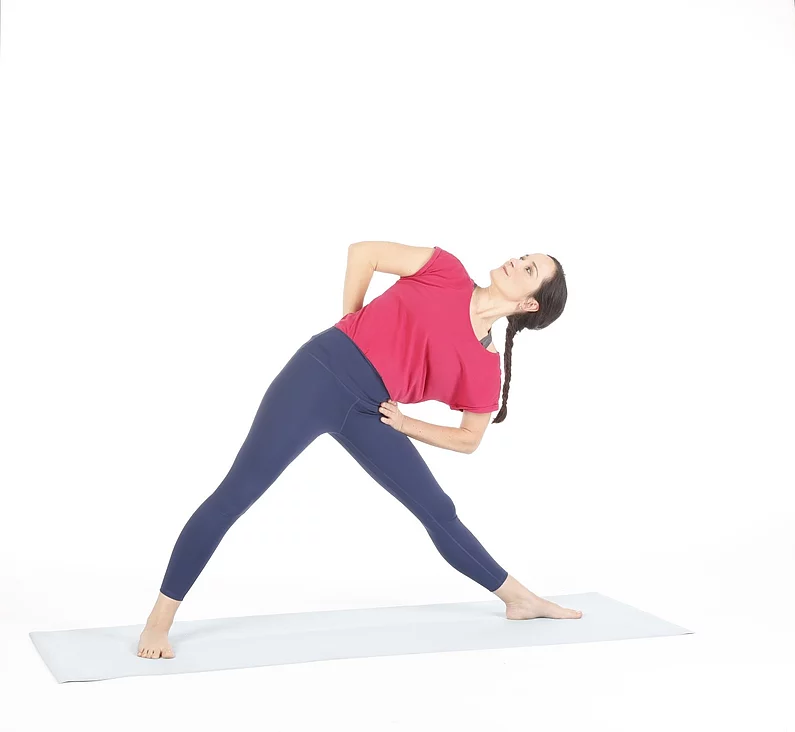 Frau praktiziert Trikonasana