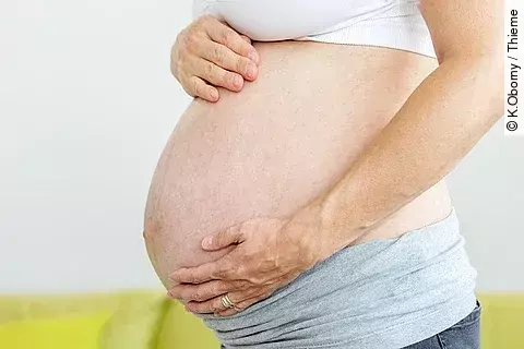 Frau hält ihren Schwangerschaftsbauch.