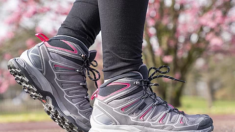 Frauenbeine in Wanderschuhen im Park