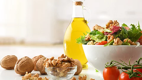 Healthy mediterranean salad with walnuts and olive oil in kitche Gesunde mediterrane Diät, Olivenöl, Salat, Nüsse