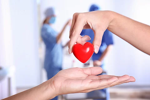 Symbolbild Organspende: eine Hand legt ein Herz in eine zweite Hand