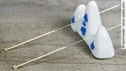 Akupunkturnadeln auf einer Porzellanhalterung