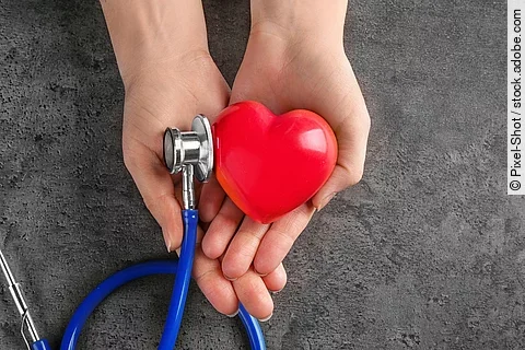 Hände halten Stethoskop mit Herz