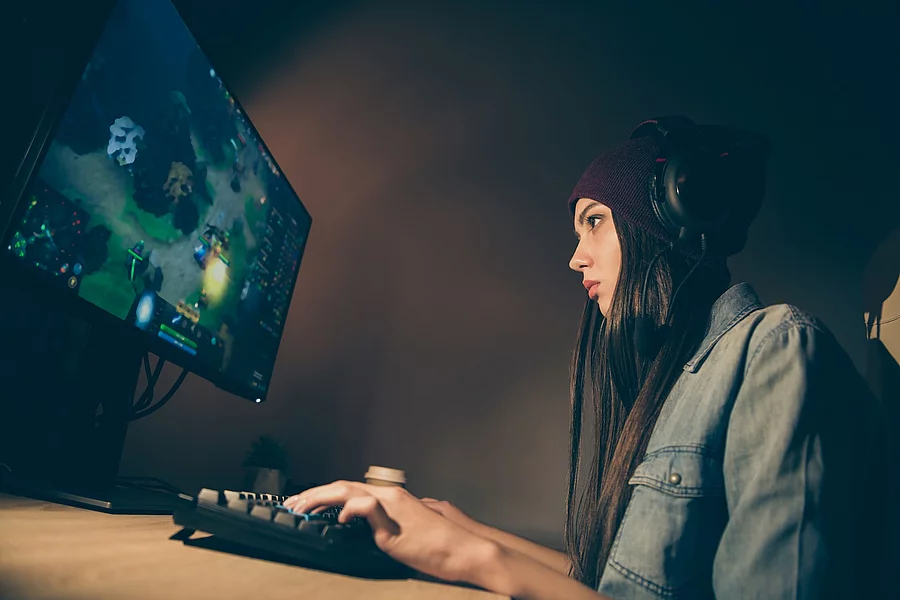 Low below angle view side profile photo of cyber sports woman co junge Frau mit Kopfhörern spielt am Computer