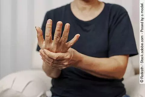 Nahaufnahme eine Mannes der sein Handgelenk mit der anderen Hand festhält